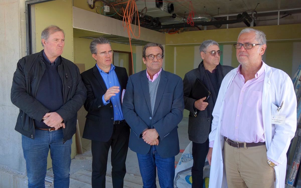 visite du chantier des urgences : photo de groupe dans le bâtiment en travaux.