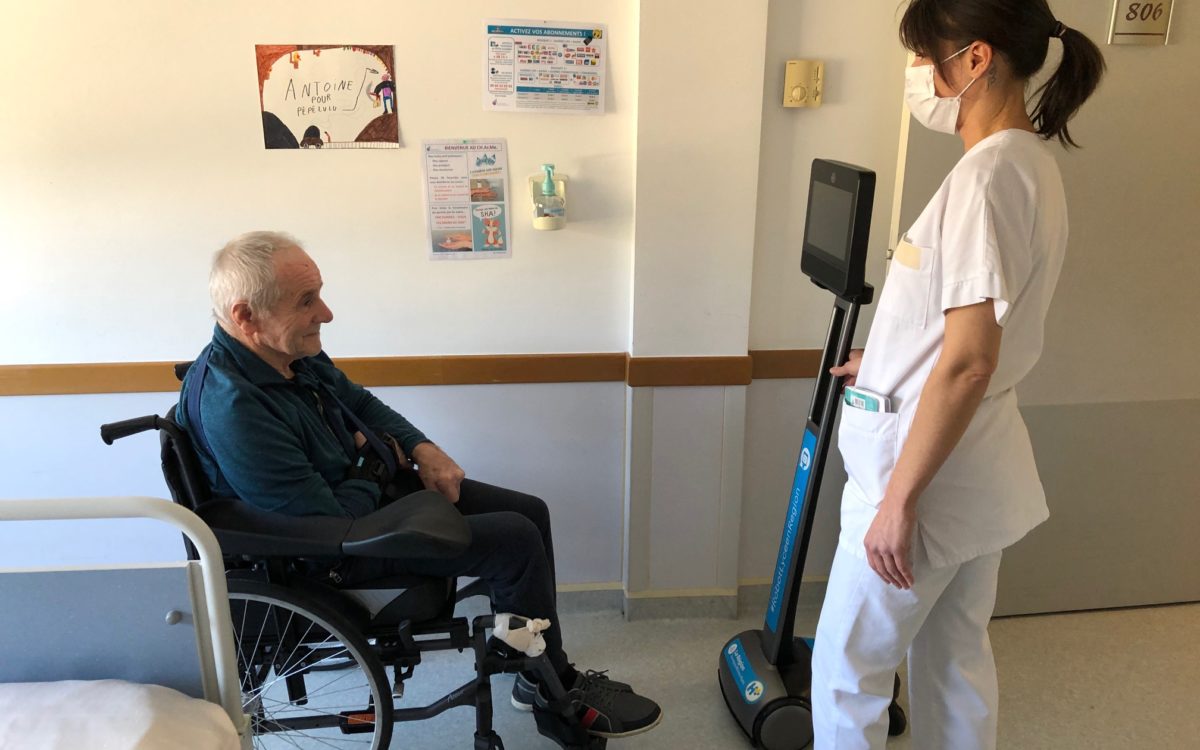 photo : patient, infirmière et et robot de téléprésence.